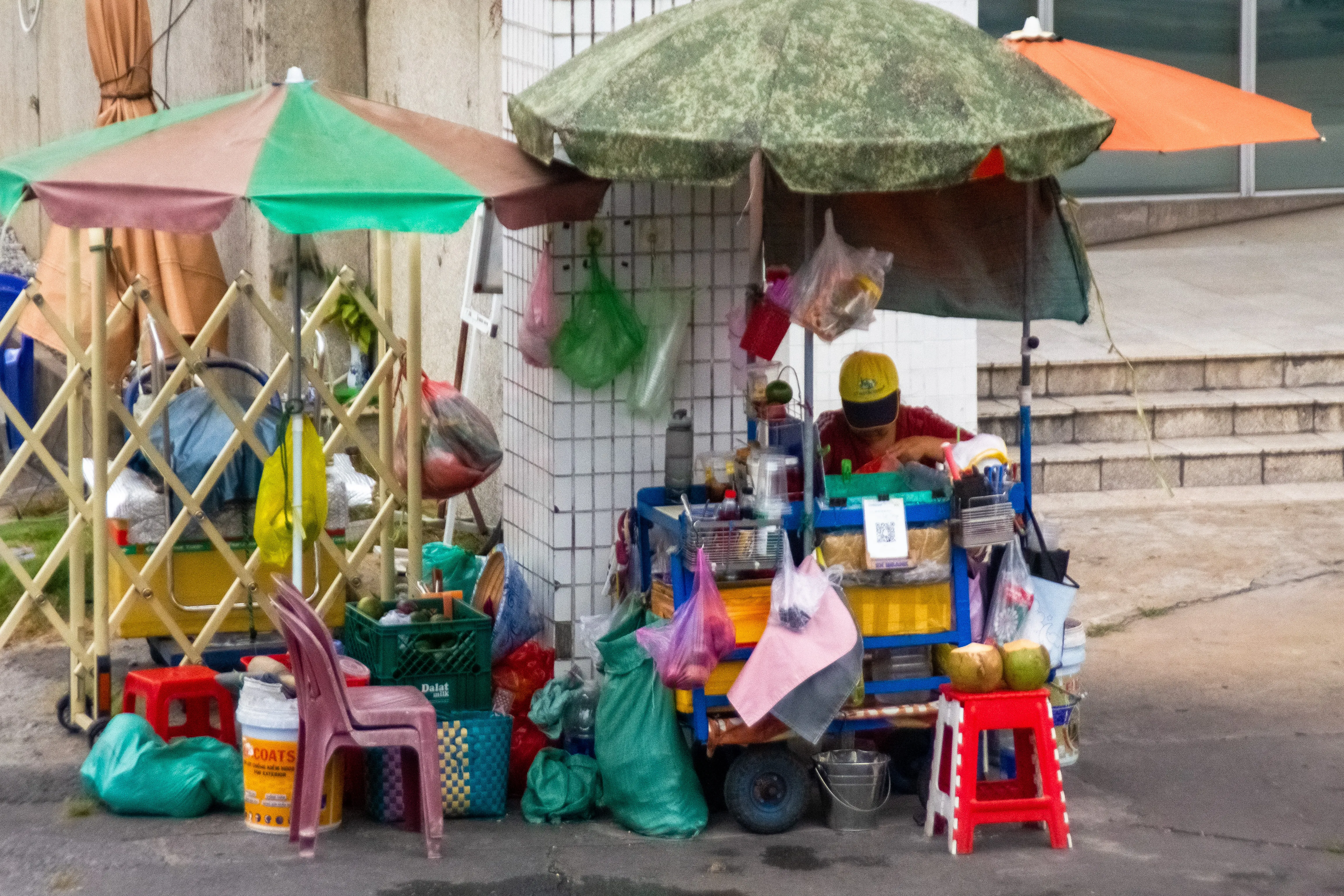 Street vendor sits outside large building